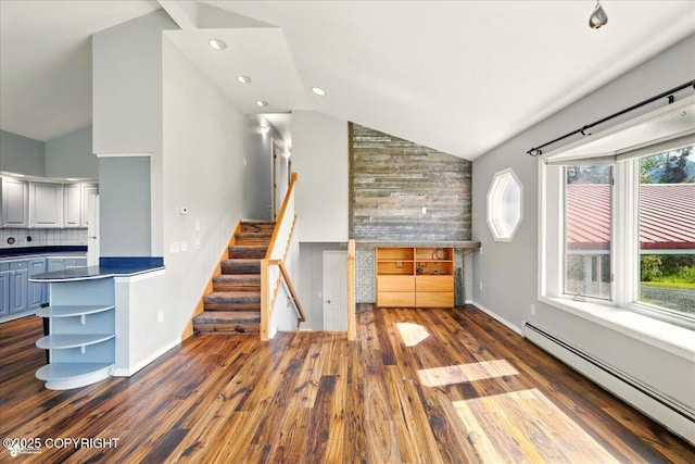 4035 S Tustin Dr, Palmer, AK 99645 - unfurnished living room featuring a baseboard heating unit, wood finished floors, stairs, baseboards, and high vaulted ceiling