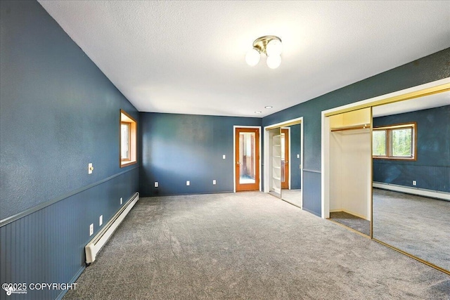 4035 S Tustin Dr, Palmer, AK 99645 - unfurnished bedroom featuring a baseboard radiator, a baseboard heating unit, two closets, and carpet