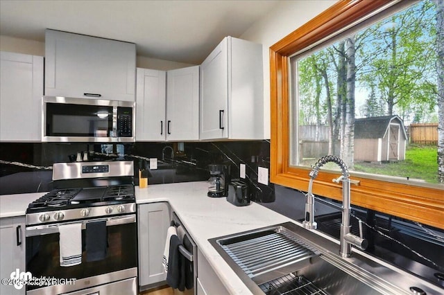 4320 Seeley Cir, Anchorage, AK 99502 - kitchen with appliances with stainless steel finishes, a sink, backsplash, and light countertops