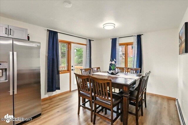 4320 Seeley Cir, Anchorage, AK 99502 - dining area featuring a baseboard heating unit, light wood-type flooring, and baseboards