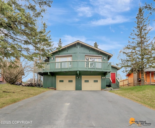 rustic home with asphalt driveway, a front yard, and an attached garage