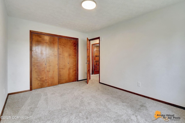 unfurnished bedroom with carpet flooring, a closet, and baseboards