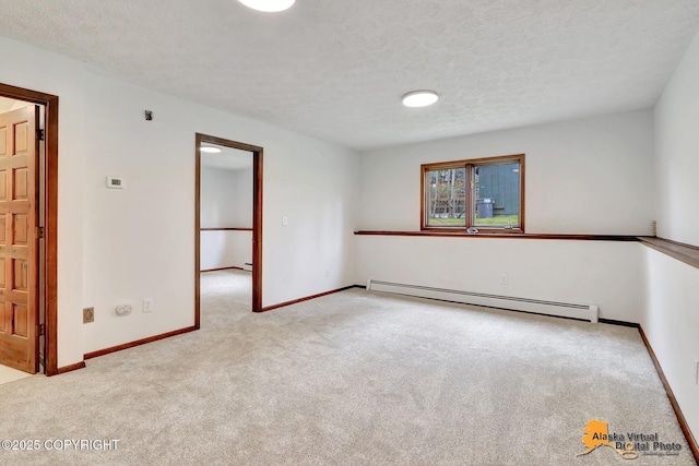 carpeted spare room with a baseboard radiator, baseboards, and a textured ceiling
