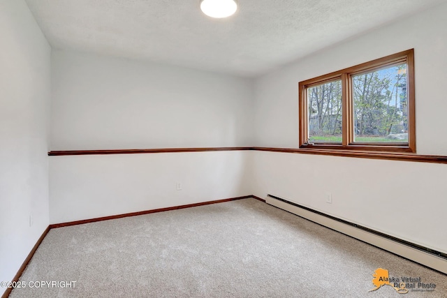carpeted empty room featuring a baseboard heating unit and baseboards