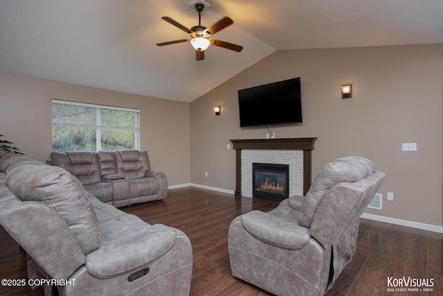 living area featuring ceiling fan, dark wood-style floors, a stone fireplace, lofted ceiling, and baseboards