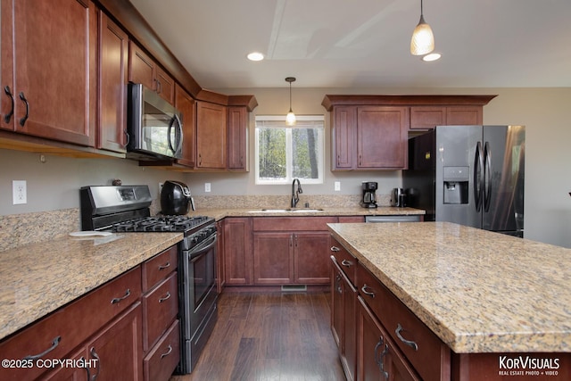 kitchen with stainless steel appliances, a sink, decorative light fixtures, dark wood-style floors, and recessed lighting