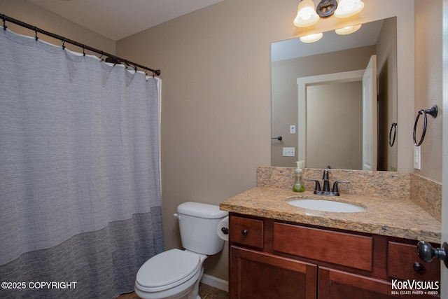 bathroom featuring vanity, toilet, and baseboards