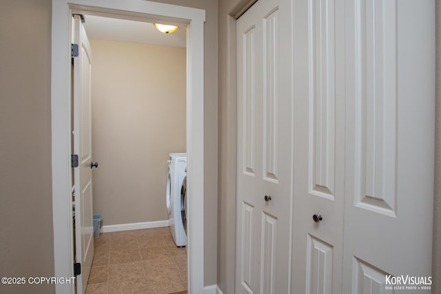 laundry area with washing machine and clothes dryer, baseboards, and tile patterned floors
