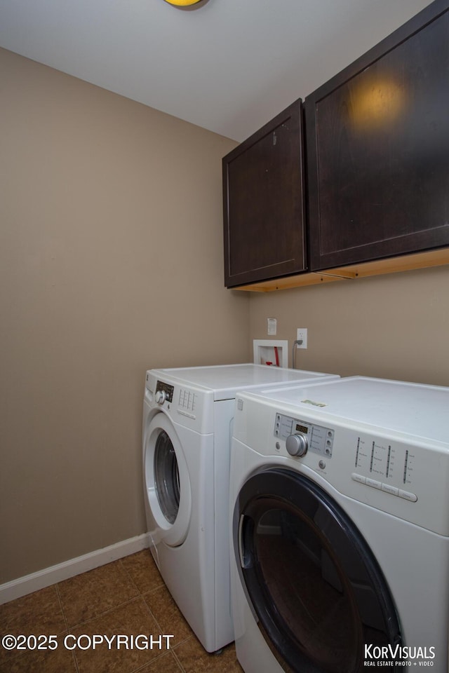 clothes washing area featuring washing machine and dryer, cabinet space, baseboards, and light tile patterned floors
