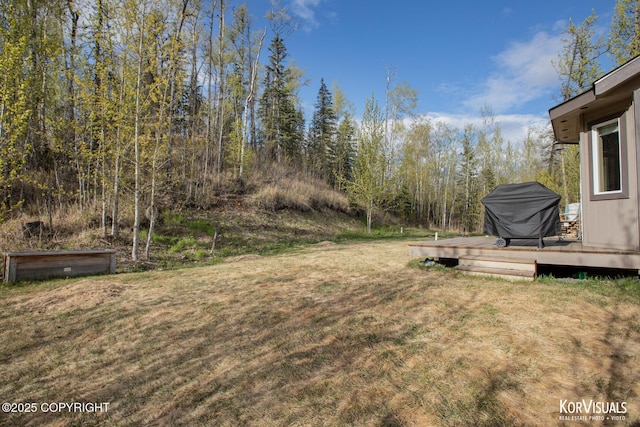 view of grassy yard featuring a deck