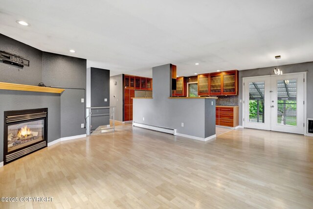 7810 Mae Rene Cir, Anchorage, AK 99502 - unfurnished living room with baseboard heating, a glass covered fireplace, light wood-style flooring, recessed lighting, and baseboards
