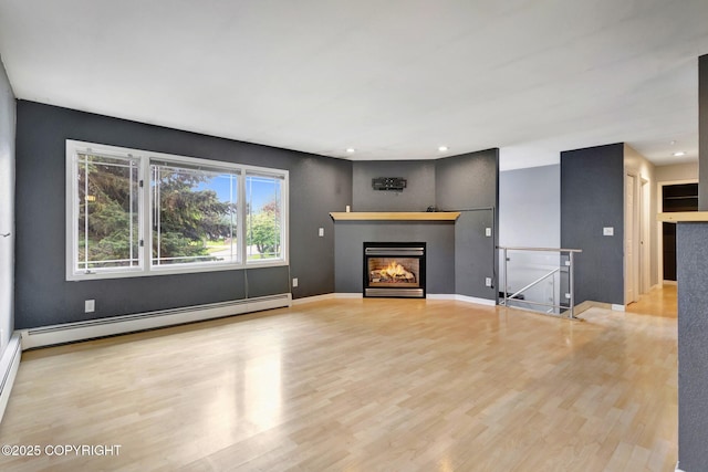 7810 Mae Rene Cir, Anchorage, AK 99502 - unfurnished living room with baseboard heating, wood finished floors, a glass covered fireplace, recessed lighting, and baseboards