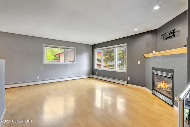 7810 Mae Rene Cir, Anchorage, AK 99502 - unfurnished living room with a glass covered fireplace, wood finished floors, a baseboard radiator, and recessed lighting