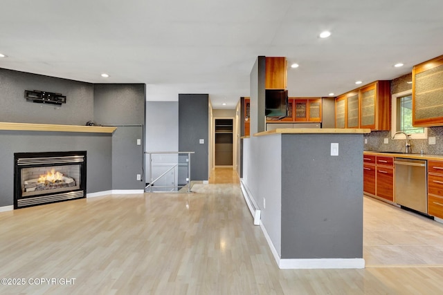 7810 Mae Rene Cir, Anchorage, AK 99502 - kitchen with stainless steel dishwasher, backsplash, a sink, glass insert cabinets, and light wood finished floors