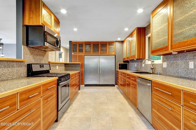 7810 Mae Rene Cir, Anchorage, AK 99502 - kitchen with appliances with stainless steel finishes, a sink, tasteful backsplash, brown cabinets, and recessed lighting