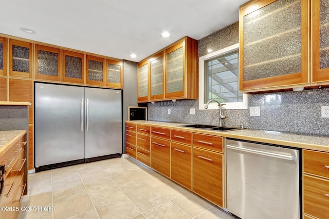 7810 Mae Rene Cir, Anchorage, AK 99502 - kitchen featuring appliances with stainless steel finishes, a sink, light countertops, tasteful backsplash, and brown cabinetry