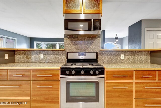 7810 Mae Rene Cir, Anchorage, AK 99502 - kitchen with stainless steel appliances, tasteful backsplash, and tile countertops