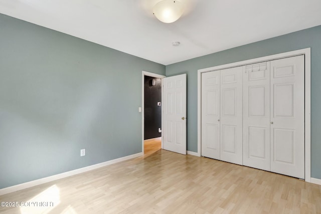 7810 Mae Rene Cir, Anchorage, AK 99502 - unfurnished bedroom featuring baseboards, light wood-style flooring, and a closet