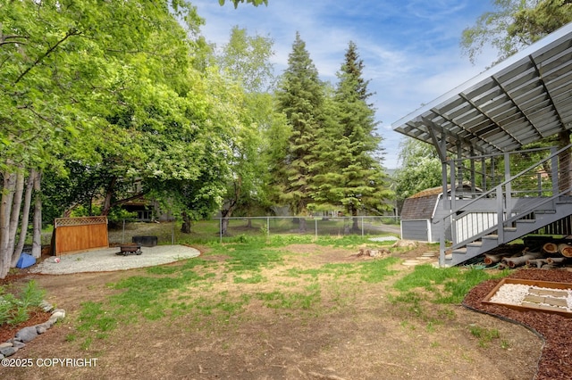 7810 Mae Rene Cir, Anchorage, AK 99502 - fenced backyard featuring a fire pit, stairs, and a patio