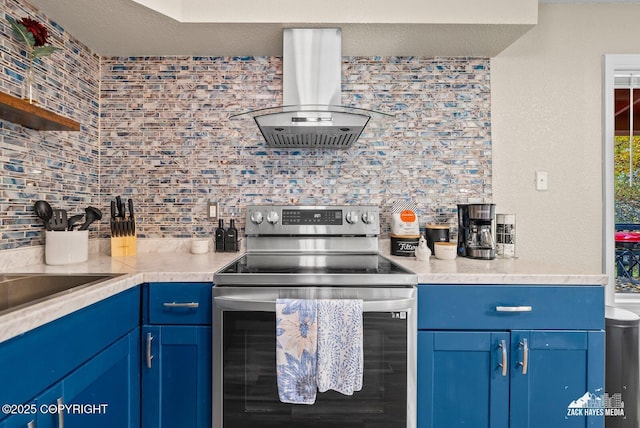 1507 W 47th Ave, Anchorage, AK 99503 - kitchen with stainless steel electric range oven, island exhaust hood, backsplash, and blue cabinetry