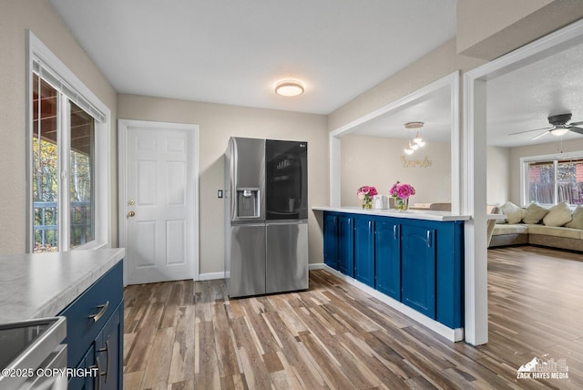 1507 W 47th Ave, Anchorage, AK 99503 - kitchen featuring blue cabinetry, stainless steel fridge with ice dispenser, light wood finished floors, and a ceiling fan