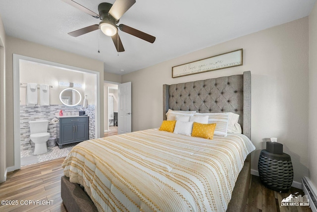 1507 W 47th Ave, Anchorage, AK 99503 - bedroom featuring wood finished floors, a baseboard heating unit, ensuite bath, and ceiling fan