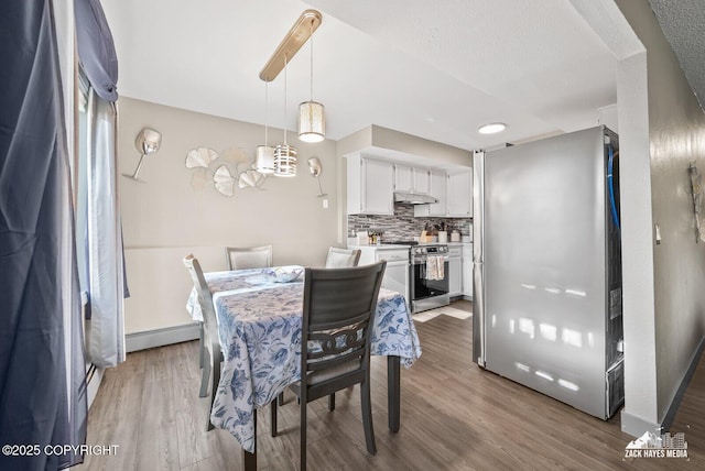 1507 W 47th Ave, Anchorage, AK 99503 - dining room with light wood finished floors and a baseboard radiator