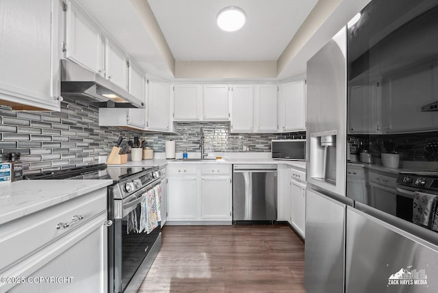 1507 W 47th Ave, Anchorage, AK 99503 - kitchen featuring appliances with stainless steel finishes, under cabinet range hood, white cabinets, and backsplash