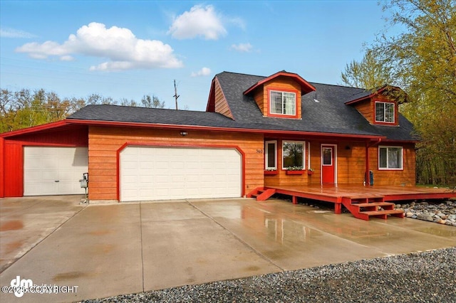 view of front of home with concrete driveway, a garage, and a shingled roof