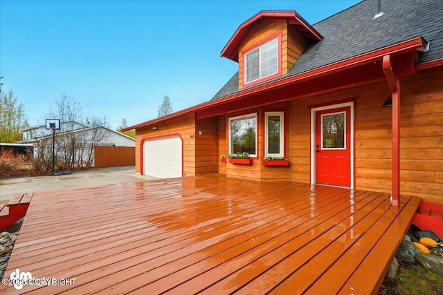 wooden deck featuring a garage and driveway