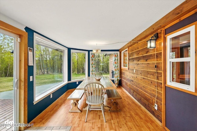 sunroom with wood finished floors and wood walls