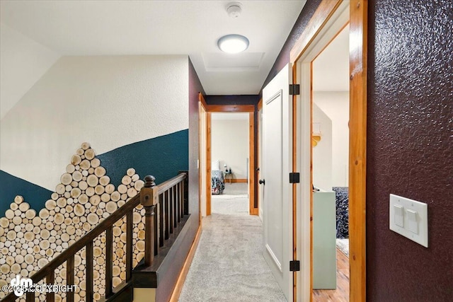 hallway featuring carpet flooring and a textured wall