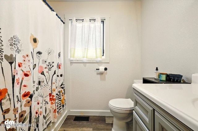 bathroom with wood finished floors, baseboards, toilet, vanity, and curtained shower