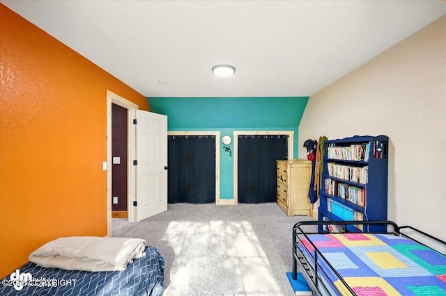 carpeted bedroom with two closets and baseboards