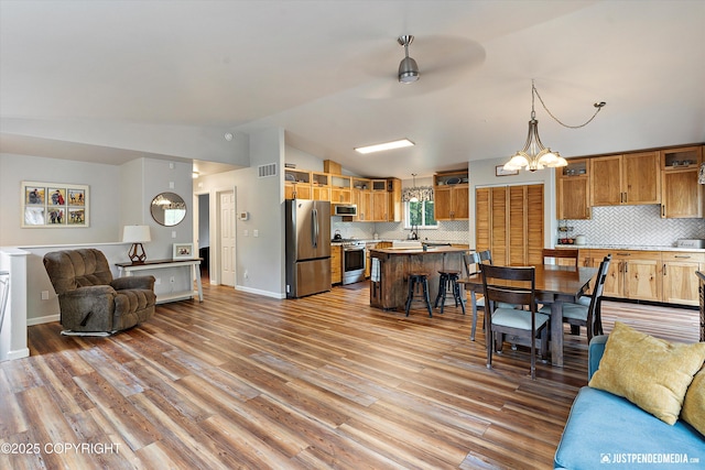 2435 N Ravens Flight Dr, Wasilla, AK 99654 - living area with lofted ceiling, wood finished floors, a ceiling fan, a chandelier, and baseboards