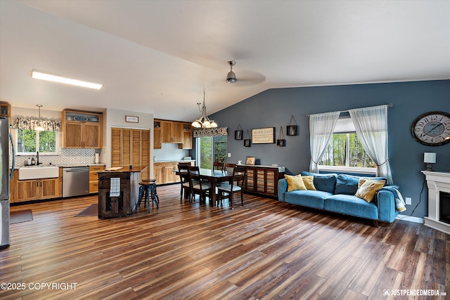 2435 N Ravens Flight Dr, Wasilla, AK 99654 - living room with plenty of natural light, wood finished floors, lofted ceiling, a chandelier, and a fireplace