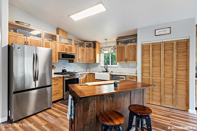 2435 N Ravens Flight Dr, Wasilla, AK 99654 - kitchen with stainless steel appliances, open shelves, wood counters, lofted ceiling, and light wood-style flooring