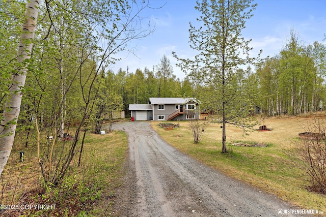 2435 N Ravens Flight Dr, Wasilla, AK 99654 - view of front of property featuring a garage, dirt driveway, a front yard, and stairs