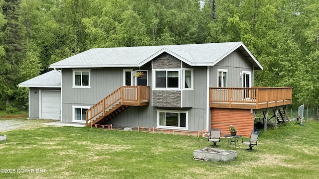 2435 N Ravens Flight Dr, Wasilla, AK 99654 - back of house featuring stairway, a lawn, a garage, a deck, and a view of trees