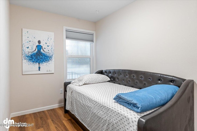 bedroom with wood finished floors and baseboards