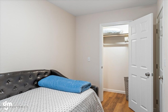 bedroom featuring wood finished floors and baseboards