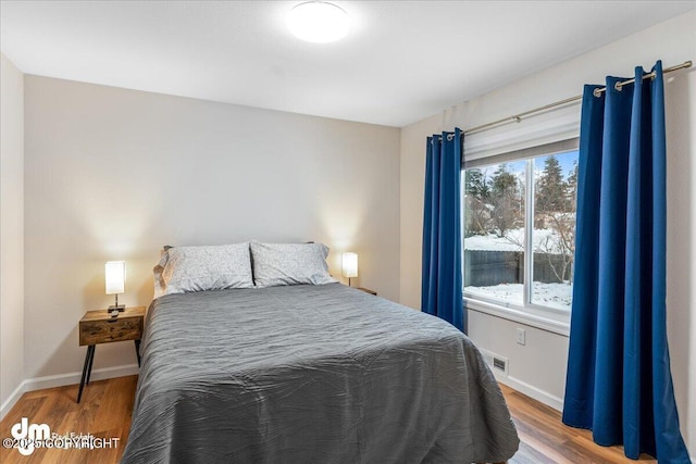 bedroom featuring wood finished floors and baseboards