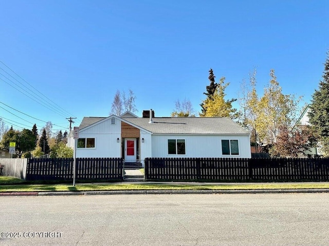 view of front of home featuring a chimney and a fenced front yard