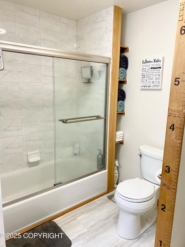 full bathroom with toilet, shower / bath combination with glass door, and wood finished floors