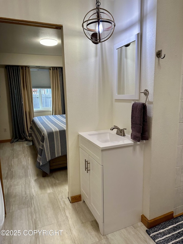 bathroom featuring baseboards, vanity, and wood finished floors