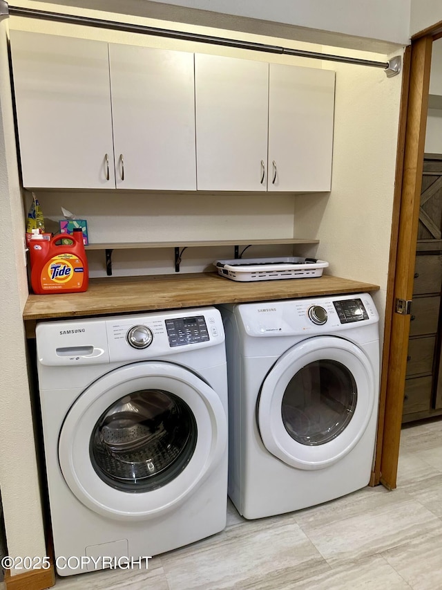 washroom featuring washing machine and clothes dryer and cabinet space