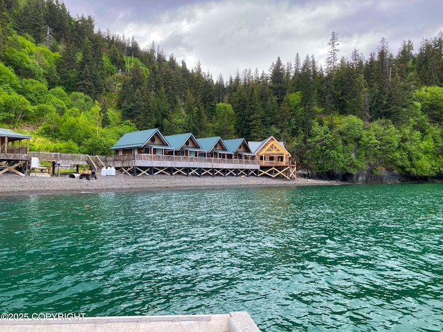 view of pool with a wooded view and a water view