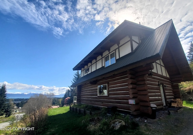 view of home's exterior with log siding and metal roof
