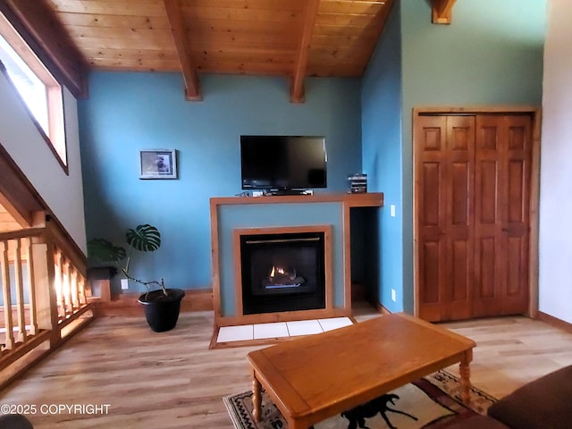 living room featuring wooden ceiling, wood finished floors, a fireplace with flush hearth, and baseboards