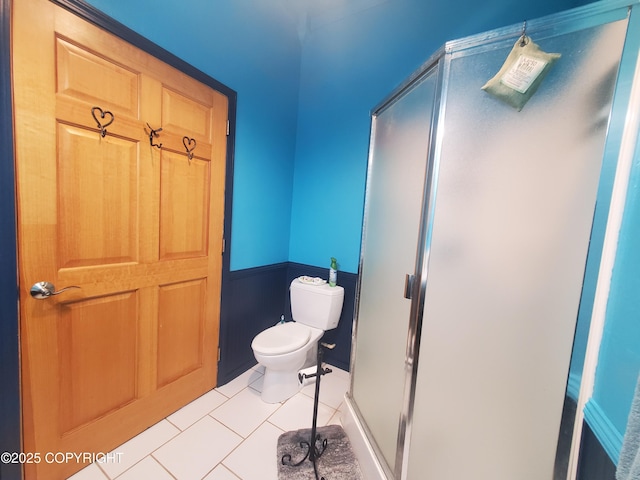 full bath with toilet, tile patterned floors, and a stall shower